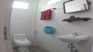 A small bathroom with a toilet, sink, and mirror. - Yuyu Golden Beach (Ko Chang)
