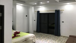 A bedroom with a bed, a sliding door, and a small seating area. - Yuyu Golden Beach (Ko Chang)