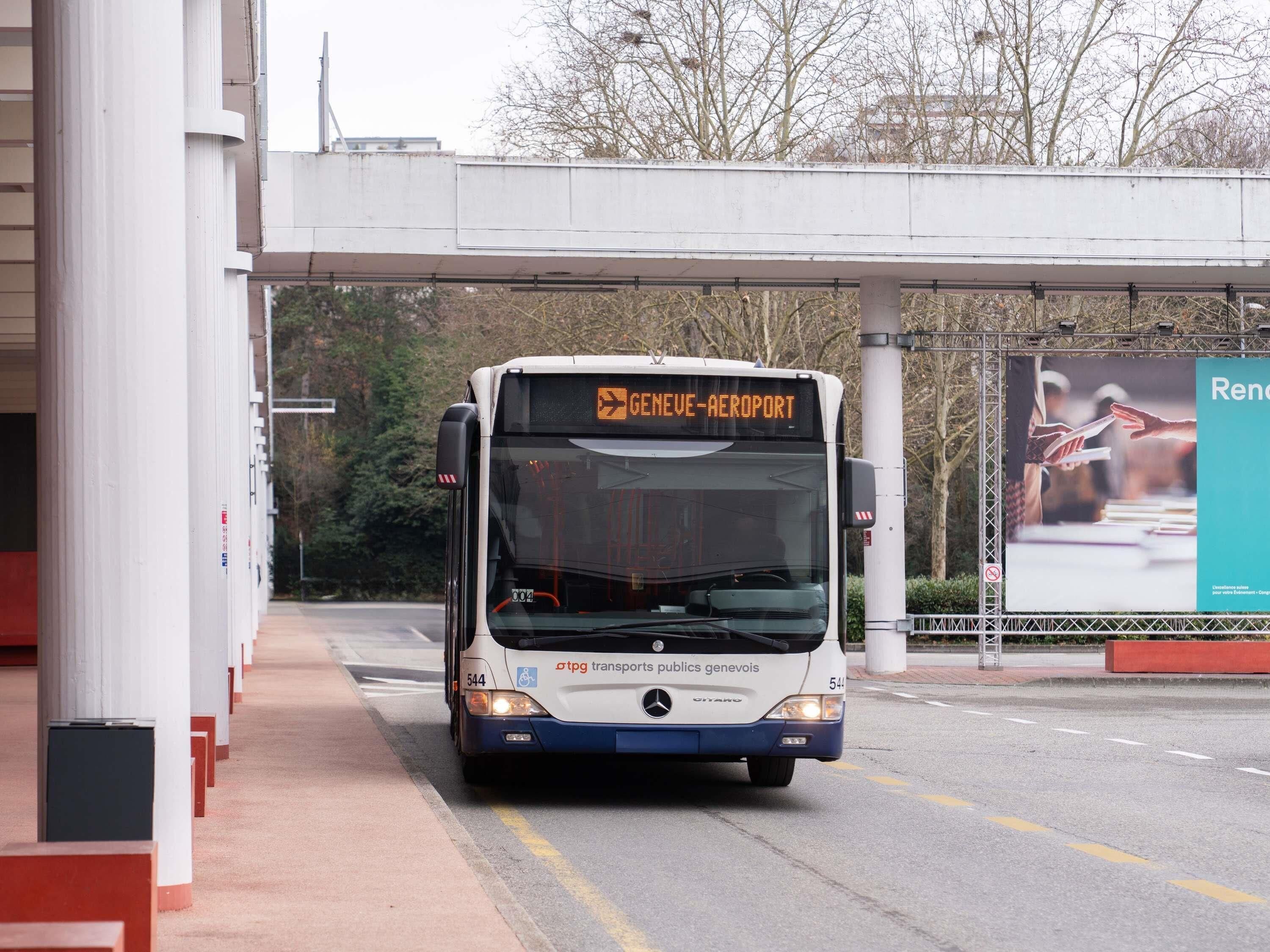 Ein Bus an einer Haltestelle, mit einem Schild für Genf-Flughafen.
