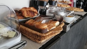 Un bufé de desayuno con diversos pasteles, pan y bebidas.