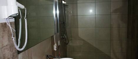 Un baño con lavabo, espejo y ducha.