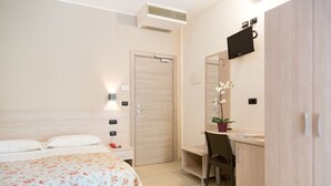 A bedroom with a bed, bedside table, desk, chair, and wardrobe. - Hotel Saint Tropez (Pineto)