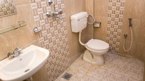 A bathroom with a toilet, sink, and shower.