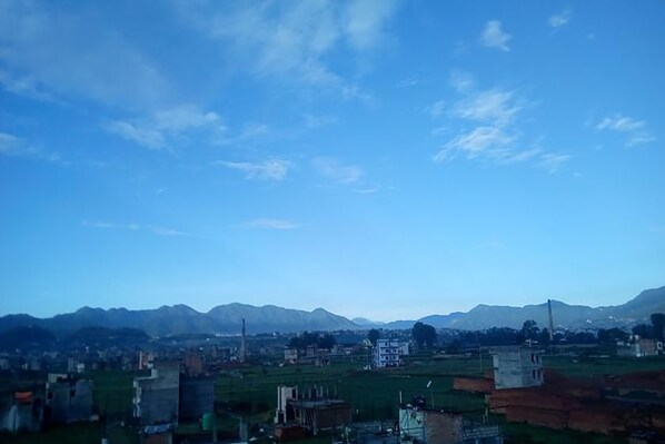 Un paisaje urbano con edificios y montañas al fondo.