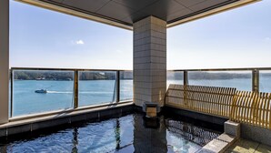 Une piscine intérieure moderne offrant une vue dégagée sur un lac et un bateau.