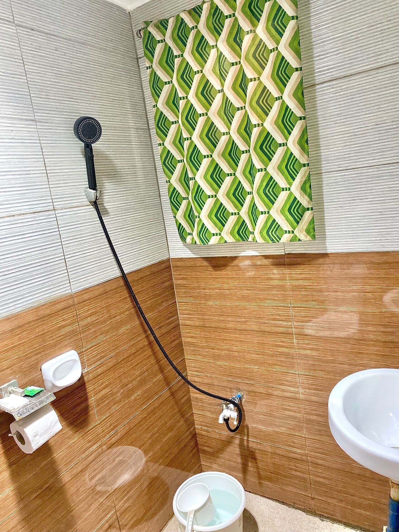 Une salle de bain avec douche, toilettes et lavabo.