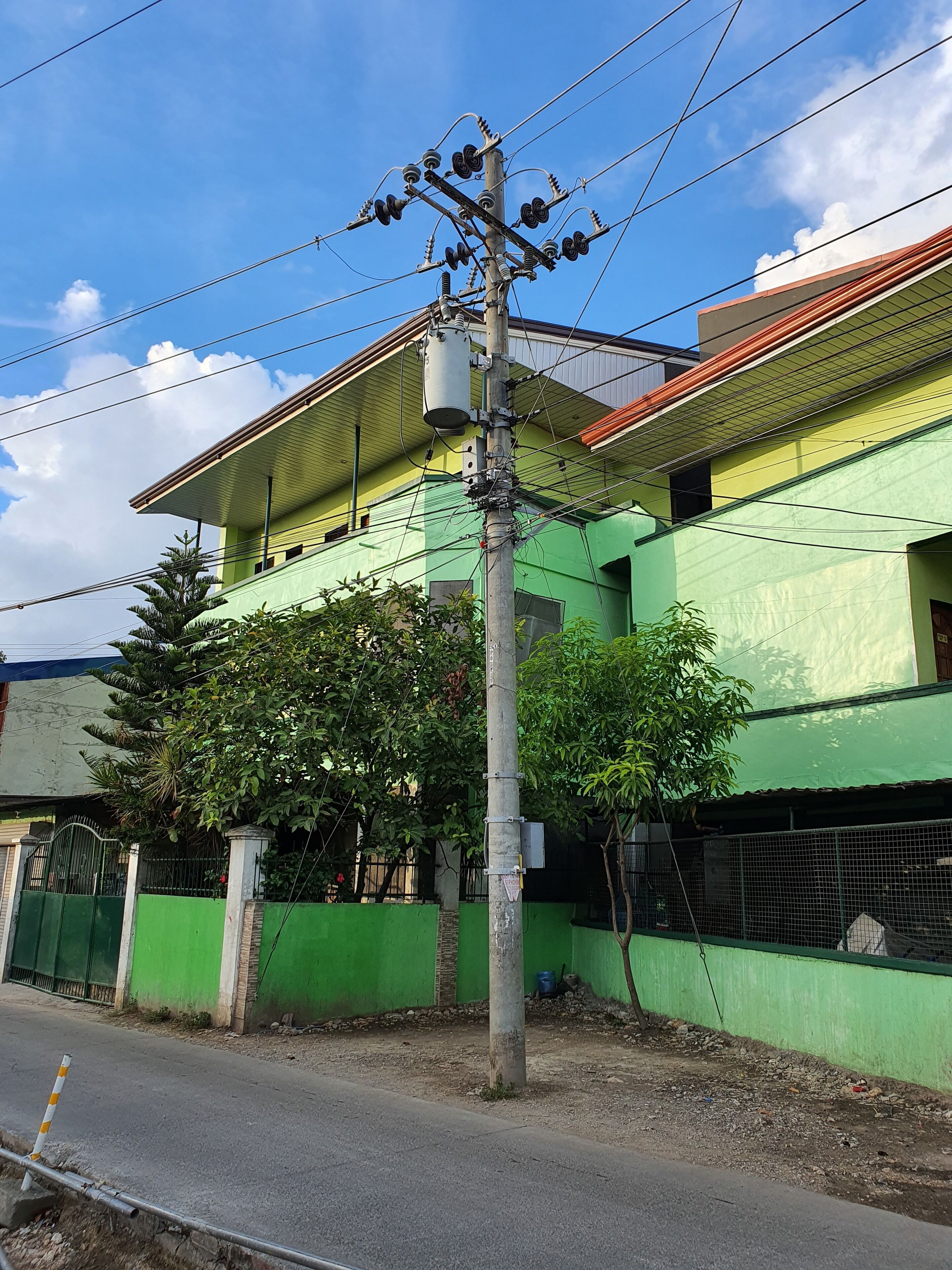 Un edificio a più piani con facciata verde e tetto rosso.