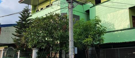 Un edificio a più piani con facciata verde e tetto rosso.