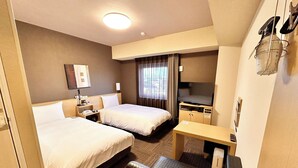 A hotel room with two beds, a desk, a TV, and a minibar. - Hotel Route Inn Anan (Anan)