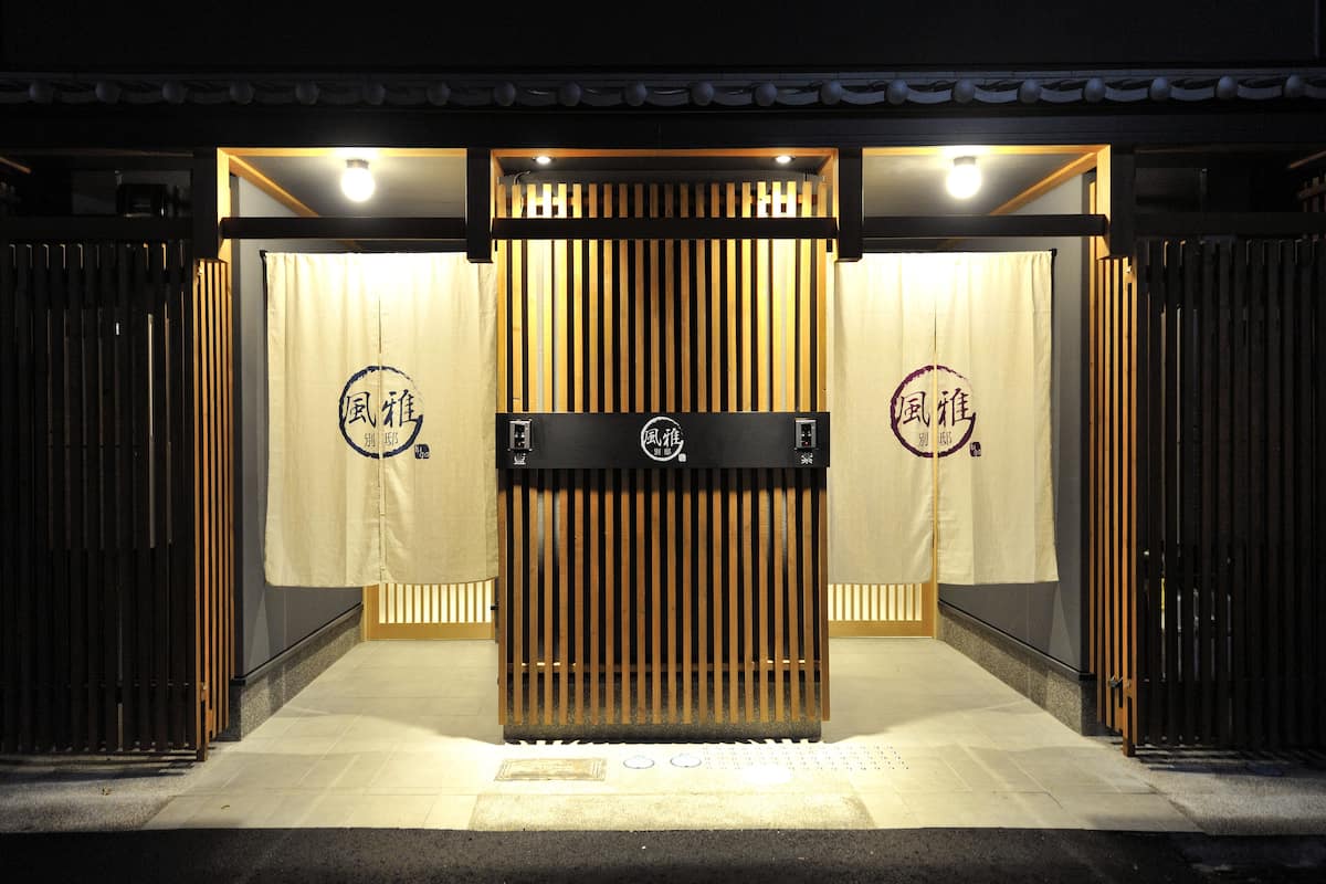 Une entrée de style japonais traditionnel, avec des portes coulissantes et une enseigne.