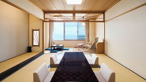 A traditional Japanese-style room with tatami flooring, a low table, and seating. - Kaisenkaku (Aomori)