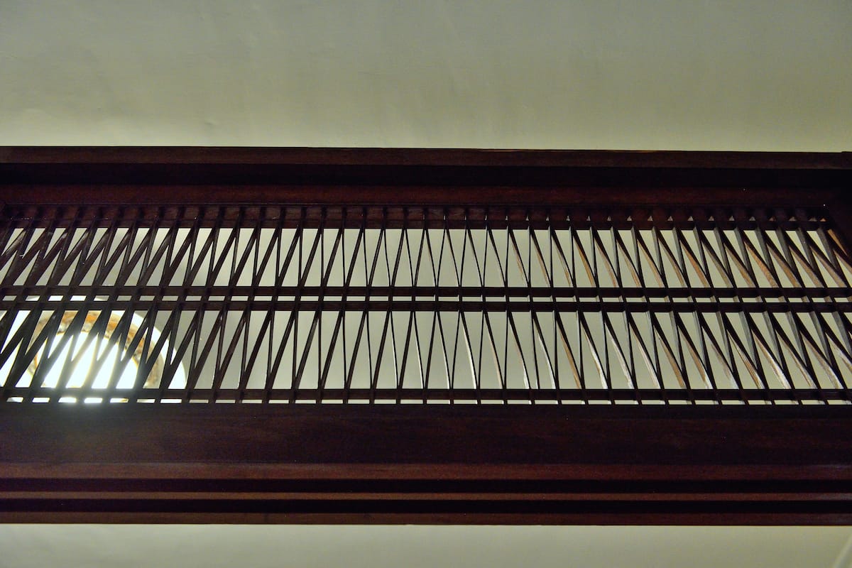 A wooden slatted ceiling with a view of the sky through the gaps.