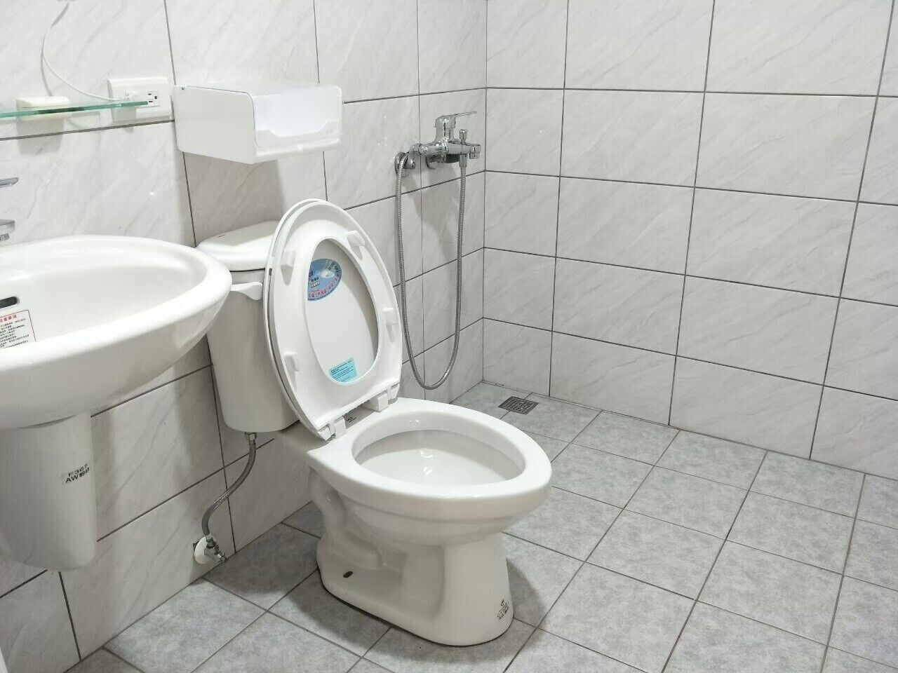 Kylpyhuone, jossa on wc, pesuallas ja suihku.