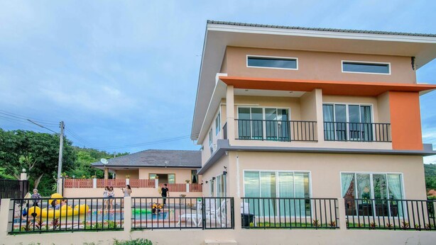 A two-story residential building with a balcony on the upper floor. - Platoo Pool Villa (Hua Hin)
