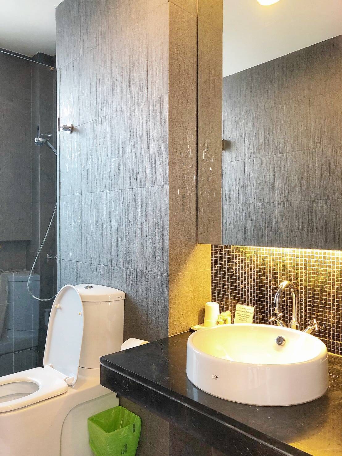 A modern bathroom with a toilet, sink, and shower.