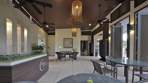 Un ambiente interno moderno con reception, area relax e ventilatori a soffitto.