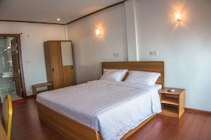 A neatly arranged bedroom with a wooden bed, bedside tables, and a wardrobe.