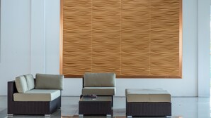 A modern living area with two sofas and a coffee table, a patterned wall, and a clean, minimalist design. - Ngapali Paradise Hotel (Thandwe)
