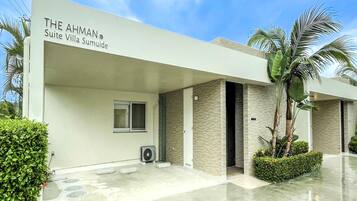 Ein moderner Hotel Eingang mit einem Schild, das "The Ahman Suite Villa Suimude" zeigt.