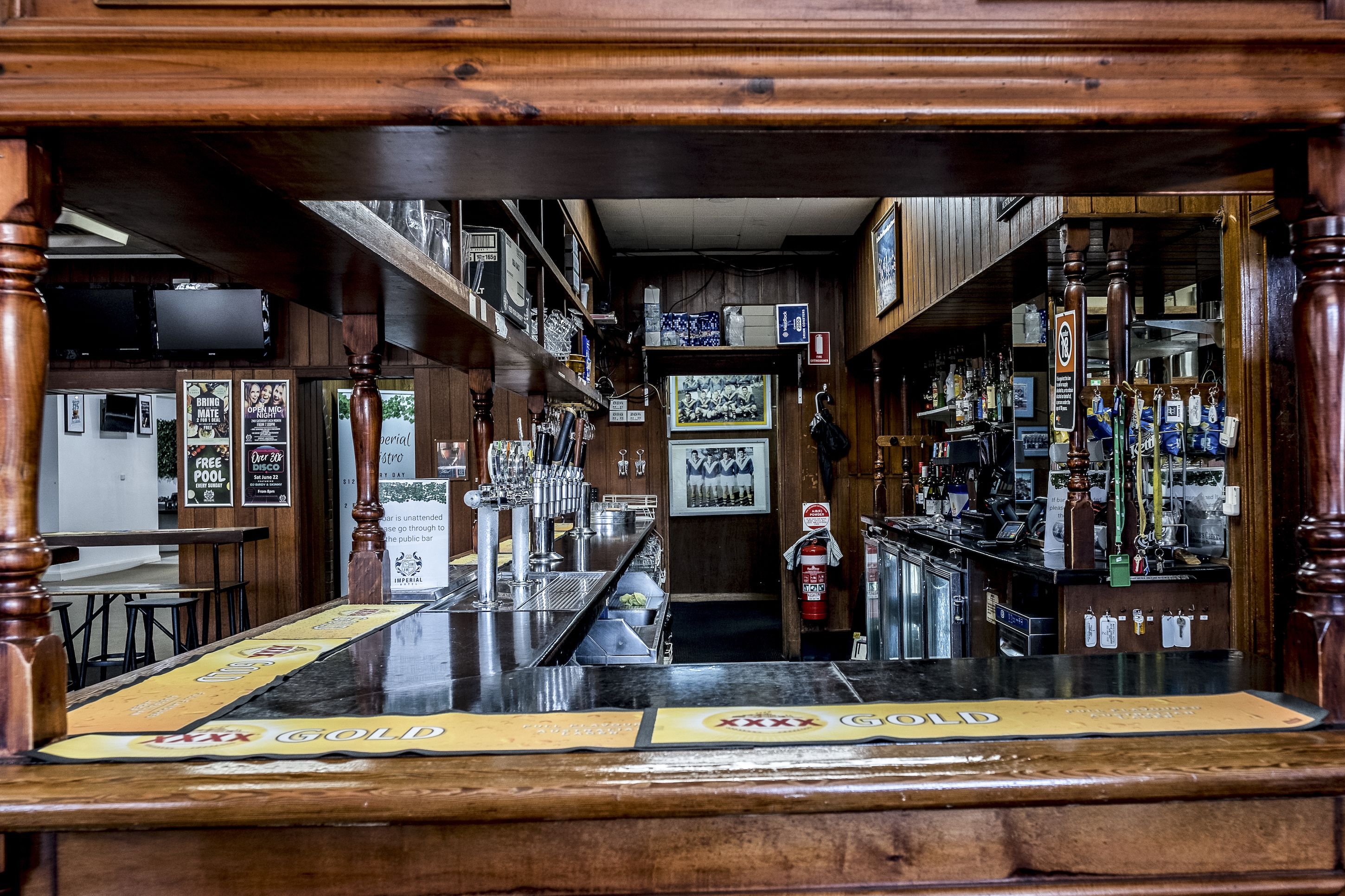 Un bar au décor en bois, avec un long comptoir et une variété de bouteilles et de verres.