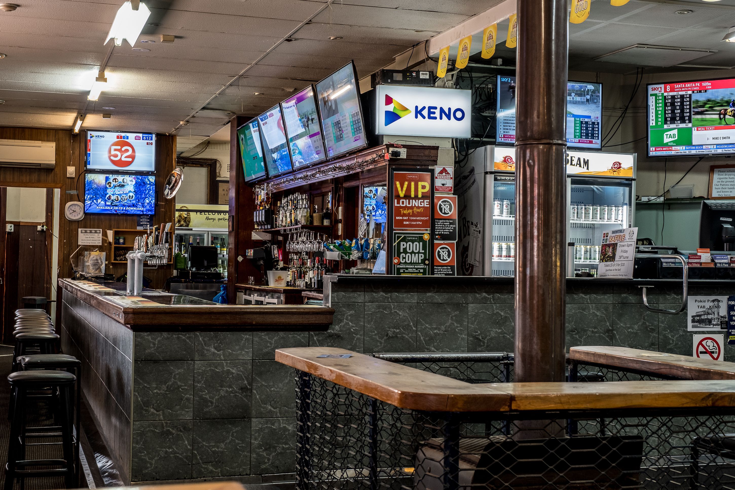 A bar area with multiple screens displaying sports and news, a KENO sign, and a VIP lounge sign.