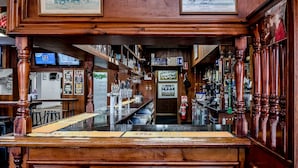 A bar with wooden bar tops and shelves stocked with bottles. - Imperial Hotel Coonabarabran (Coonabarabran)