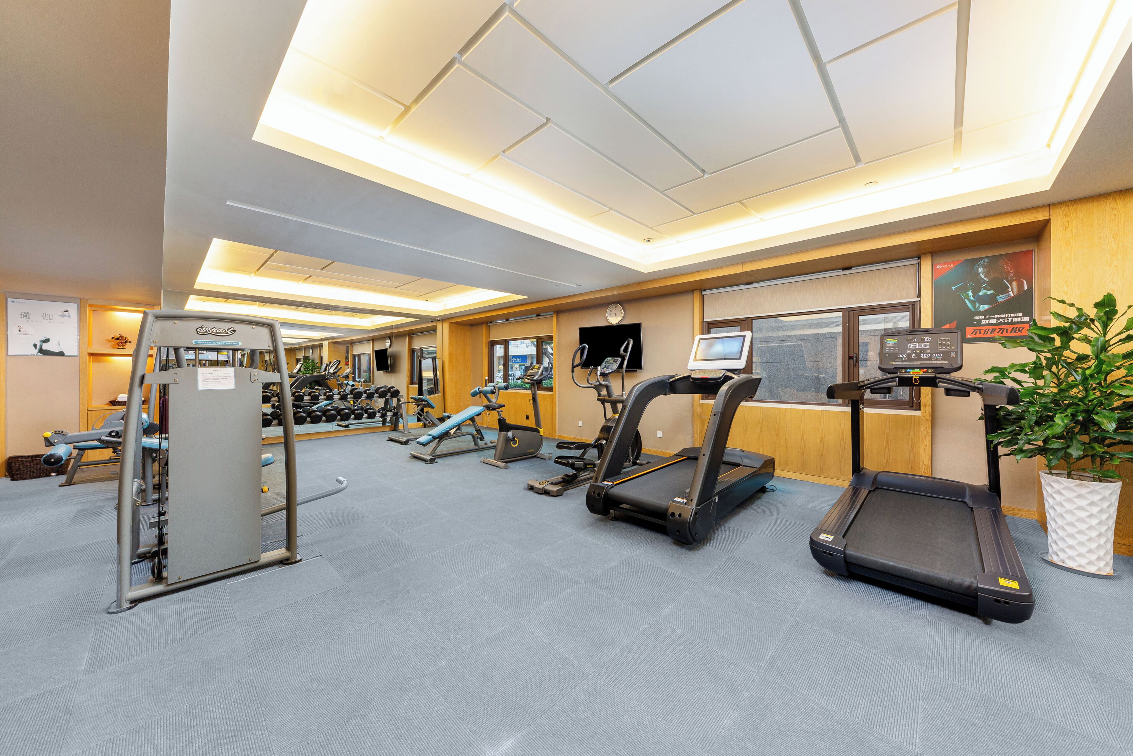 A gym with treadmills, weight machines, and a reception desk.