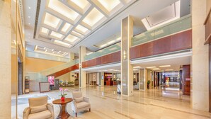 A spacious lobby with a high ceiling, a reception desk, seating area, and a staircase. - Xiamen Huli Yiho Hotel (Xiamen)