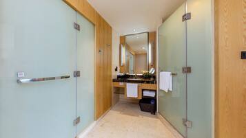 A modern bathroom with a glass shower enclosure, a wooden vanity, and a mirror above the sink.