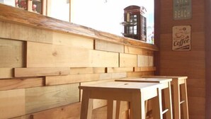 Un espace avec des bancs en bois, un mur en bois et une enseigne indiquant un café.