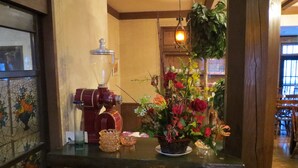 A kitchen counter with a coffee machine, a blender, and a floral arrangement. - Pension Marionette (Hakuba)