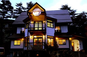 A two-story building with a sign reading "PENTON M'RONEE." - Pension Marionette (Hakuba)