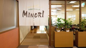 Un couloir de bureau avec une banderole sur laquelle on peut lire « MINORI » et des plantes en pot.