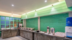 Una cocina moderna con una pared verde, encimera de mármol y diferentes utensilios de cocina.