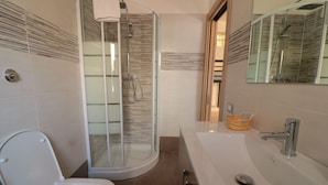 A modern bathroom with a glass-enclosed shower, a white sink, and a mirror. - B&B Pietrarsa (Portici)