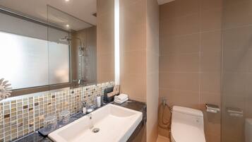 A modern bathroom with a large sink, mirror, and toilet.