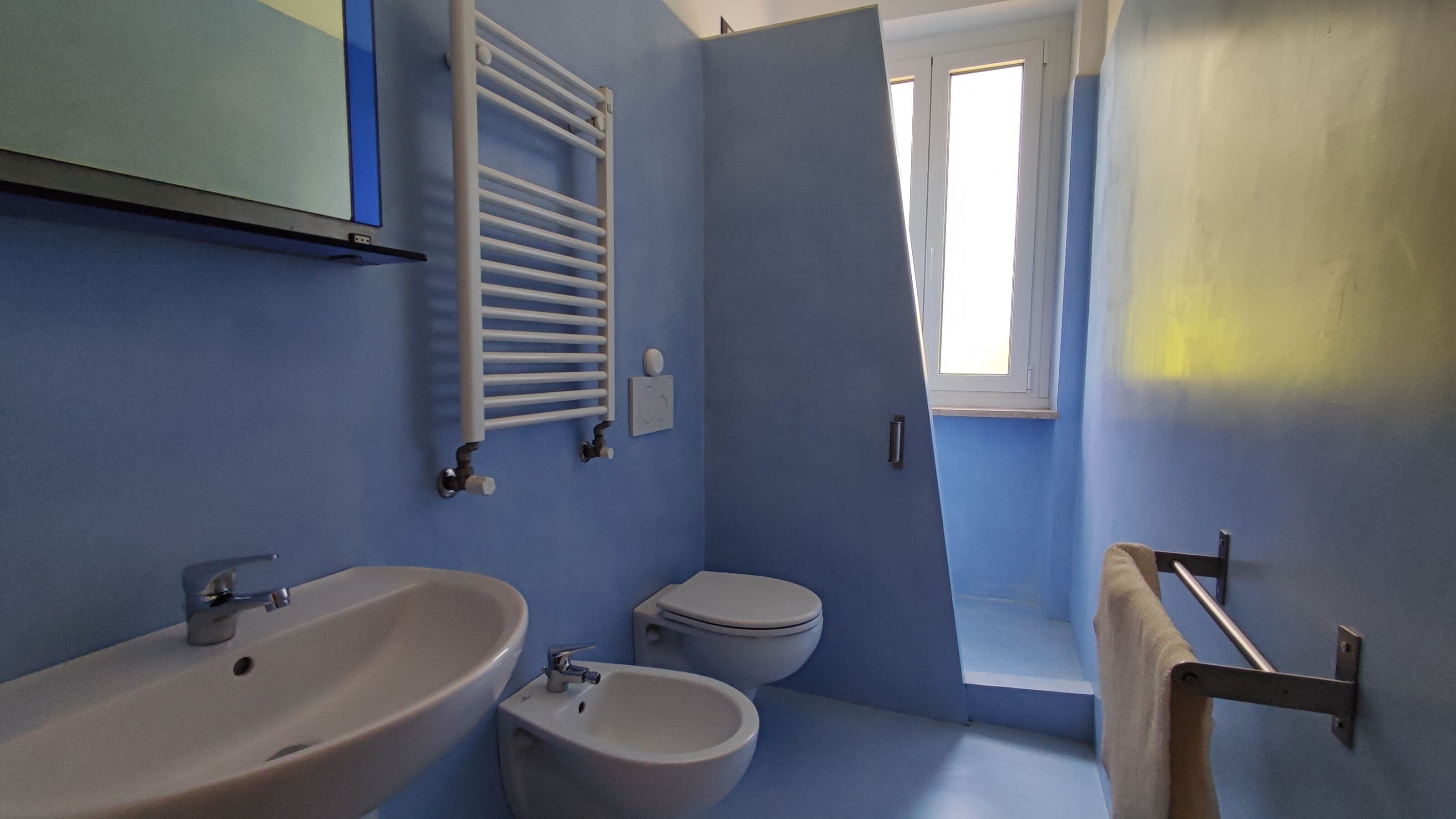 Ein Badezimmer mit Waschbecken, Bidet, Toilette und Handtuchhalter.