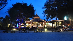 A beachside bar with outdoor seating and a thatched-roof structure. - Samui Honey Backpacker Bungalow (Koh Samui)