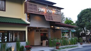 The exterior of Samu Honey Resort with a prominent sign, a covered entrance, and potted plants. - Samui Honey Backpacker Bungalow (Koh Samui)