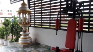 A gym with exercise equipment, a decorative fountain, and potted plants. - R.M. Mansion Surin (Surin)