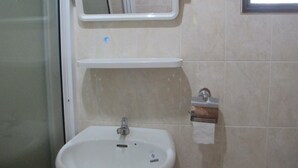 A bathroom with a white sink, a mirror above it, and a towel dispenser to the right. - Phuendernthang Resort (Tha Chang)