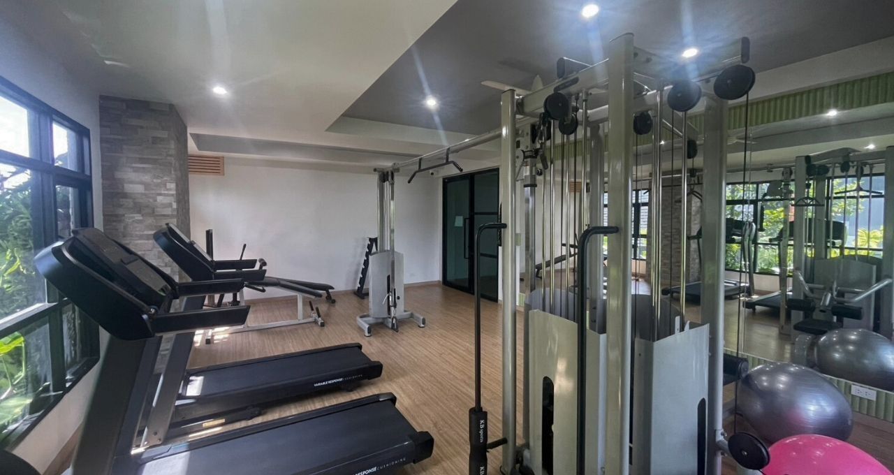A gym with treadmills, weight machines, and exercise balls.