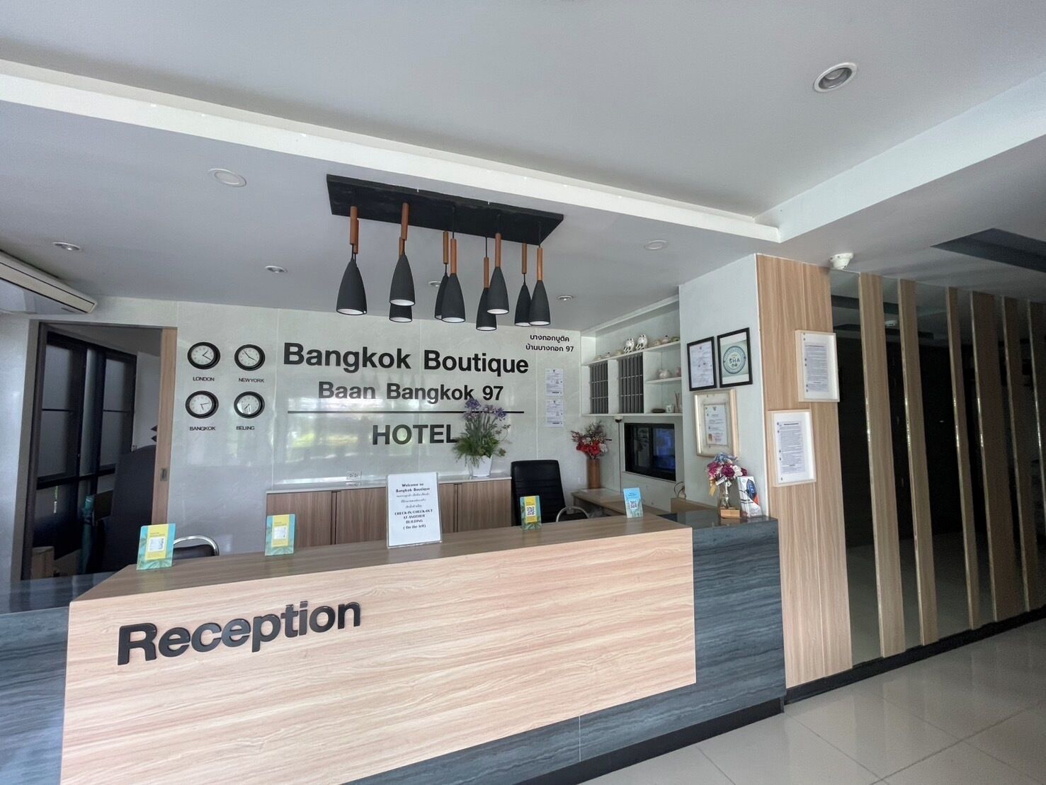 Zona de recepción de un hotel con un cartel que indica 'Bangkok Boutique Baan Bangkok 97 HOTEL'.