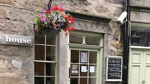 A stone building with a sign reading "The Coffee House" and a flower basket hanging above the entrance. - The Coffee House Hotel (Aberdeen)