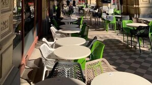 An outdoor cafe with ornate arches, round tables, and green chairs. - KH Apartments (Vienna)