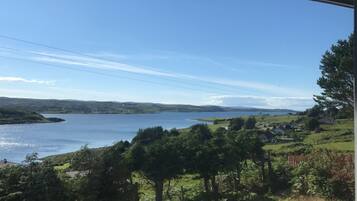 A coastal landscape with a lake, houses, and trees.