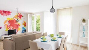 Un salon moderne avec un canapé, une table à manger et un téléviseur.