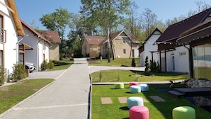 Un quartier résidentiel doté d’une promenade dallée, de coins salons extérieurs aux couleurs vives et d’un petit élément décoratif aquatique.