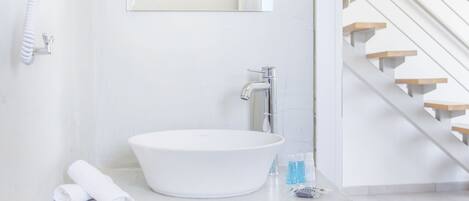 Un baño moderno con un lavabo blanco grande, un espejo y una toalla colgada en la pared.