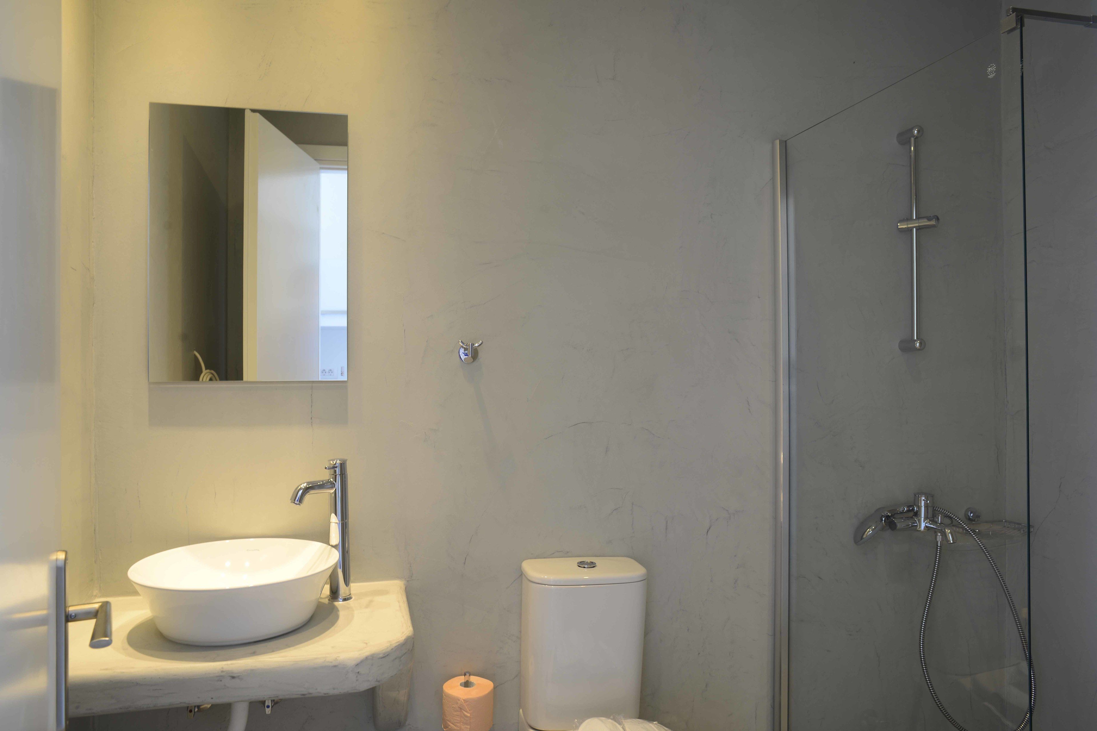 A bathroom with a white sink, a toilet, and a glass-enclosed shower.